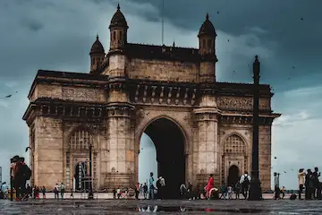 Gateway of India Mumbai - iconic colonial monument with tourists, cloudy sky