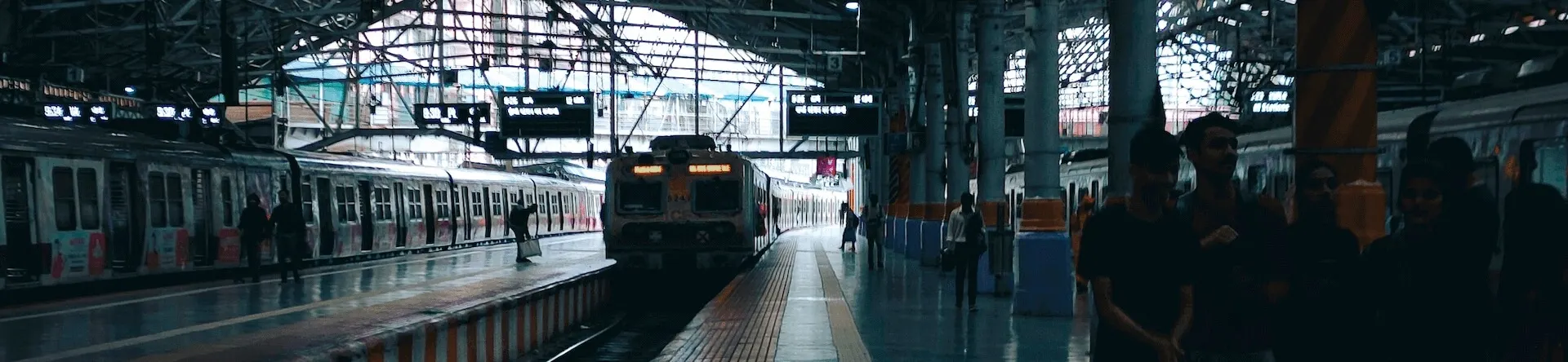 Mumbai local train arriving at station platform - commuters waiting, wide view